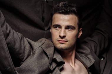 Stüdyoda poz veren genç yakışıklı adam.