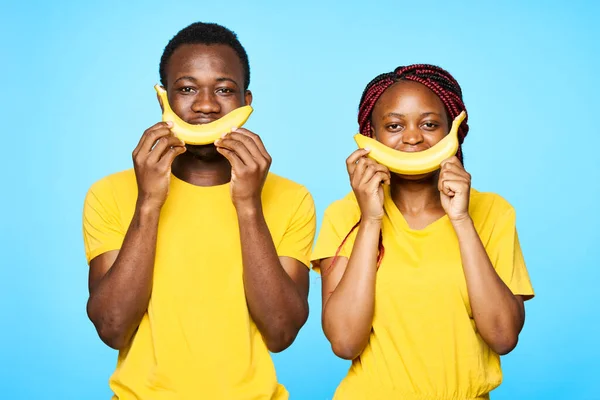Jovem Belo Casal Fazendo Sorrisos Com Bananas Estúdio Fundo Azul — Fotografia de Stock