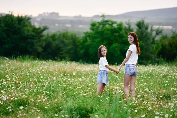 若いです母と彼女の娘持っています楽しいです上のカモミールフィールド — ストック写真