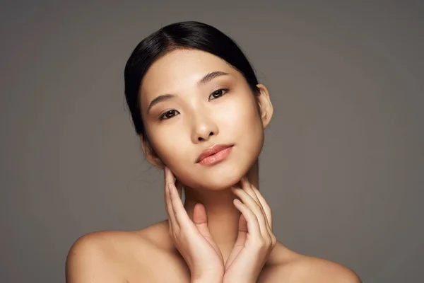 Portrait of  beautiful asian woman touching face   on isolated background