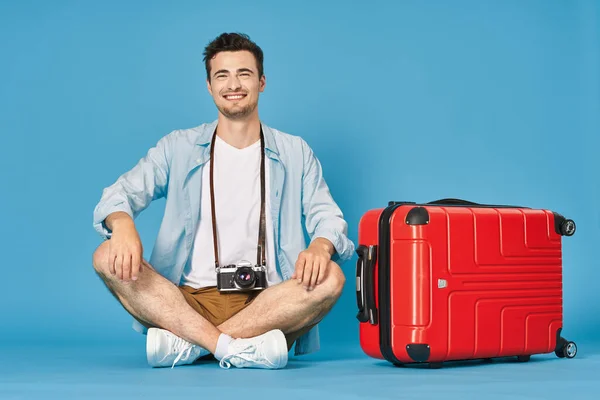 若いです男とともに赤いスーツケースでスタジオ — ストック写真