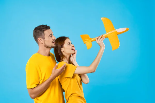 Νεαρό Όμορφο Ζευγάρι Παίζει Κίτρινο Παιχνίδι Αεροπλάνο Μπλε Φόντο — Φωτογραφία Αρχείου