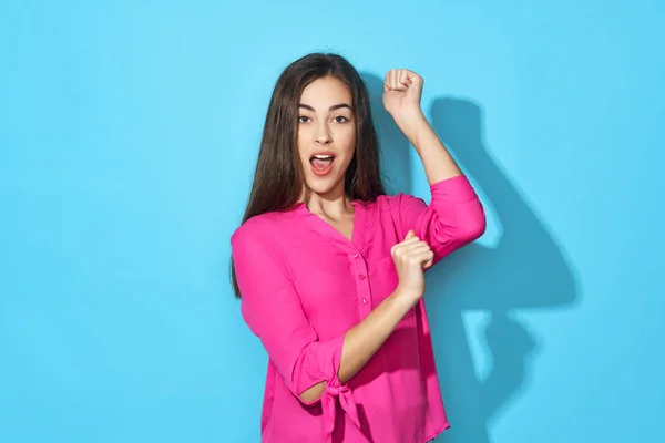 Young beautiful woman with fists    in studio isolated on blue background