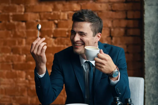 Young   happy businessman with coffee cup   in the office