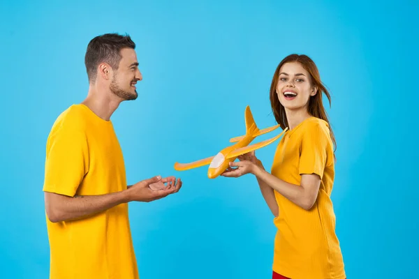 Jong Mooi Paar Spelen Met Geel Speelgoed Vliegtuig Blauwe Achtergrond — Stockfoto