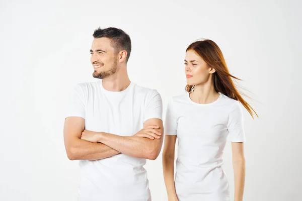 young beautiful couple in  t-shirts posing in studio on isolated background
