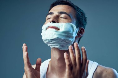 Genç ve yakışıklı bir adamın traş olurken çekilmiş bir fotoğrafı. 