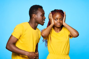 Afrika görünümlü erkek ve kadın izole edilmiş arka planda bir sırrı paylaşıyorlar.