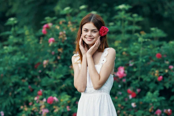 花园里开着玫瑰花的年轻女子 — 图库照片