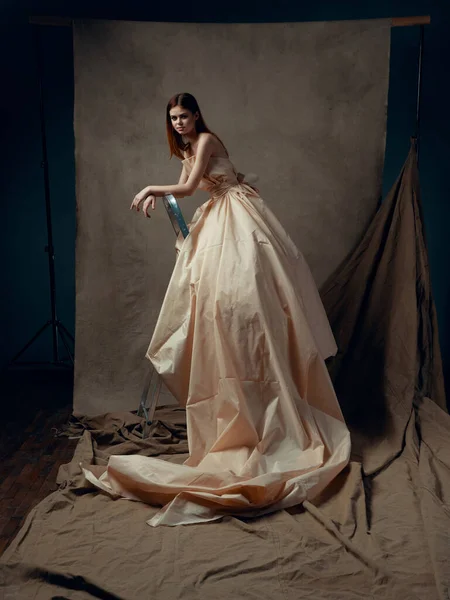 Young beautiful woman in gown posing in studio