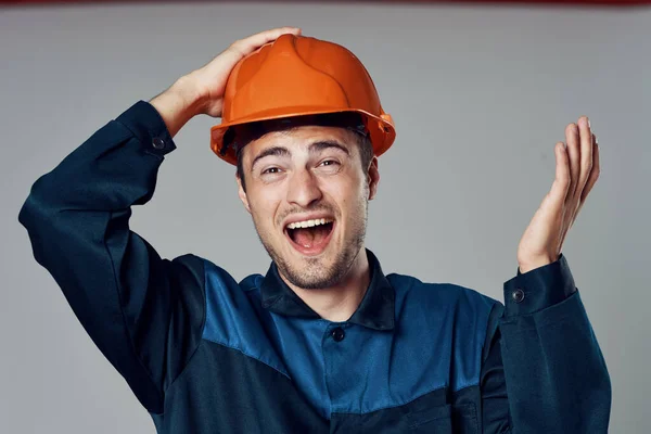 Studio shot. Industrial  worker in orange helmet is happy