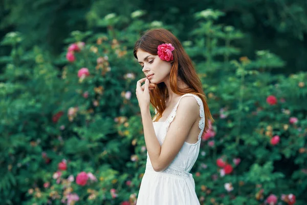 花园里开着玫瑰花的年轻女子 — 图库照片