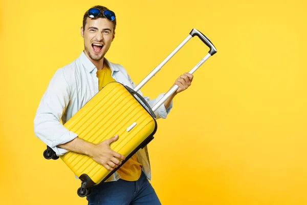 Muž cestovatel s kufrem, barevné pozadí, radost — Stock fotografie