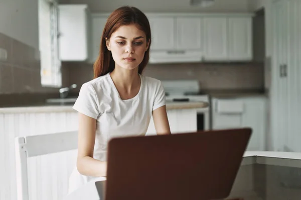Mujer joven con un ordenador portátil en la mesa de trabajo —  Fotos de Stock