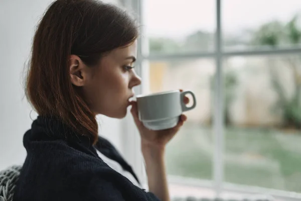 Женщина возле окна чашки кофе — стоковое фото