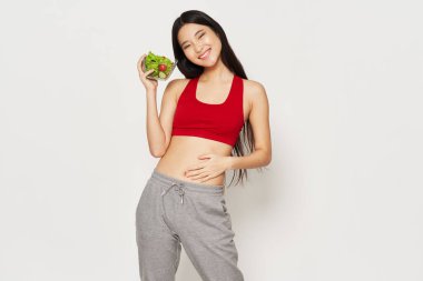 Kırmızı tişörtlü, diyet sebzeli, tabak mankenli güzel bir kadın. 