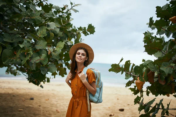 Hermoso viajar en un vestido de sol cerca de los árboles en la isla sonriendo — Foto de Stock