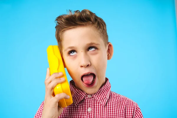 Vacker pojke talar på telefonen leksak tablett fall — Stockfoto