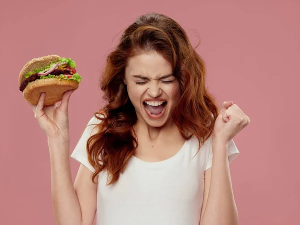 Emotionele vrouw met hamburger fast food dieet — Stockfoto