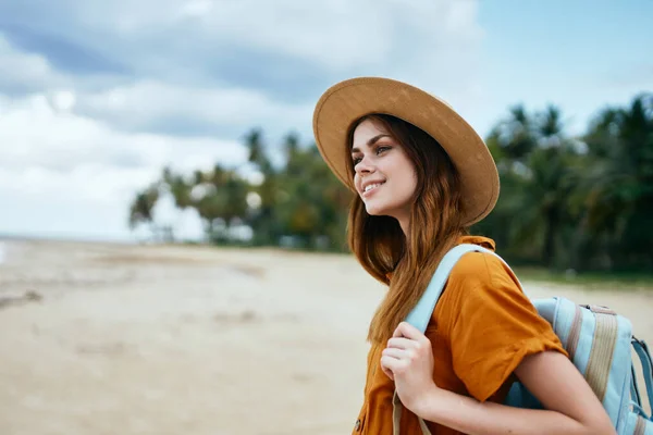 En lycklig resenär vilar på ön bland palmer och en ryggsäck — Stockfoto