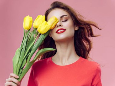 Kapalı gözleri ve bir buket çiçekleri olan büyüleyici bir kadın.