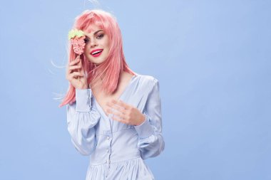 Pembe saçlı güzel kadın bir pasta tutuyor. 