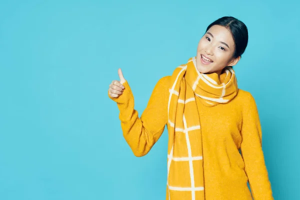 Chica feliz sobre un fondo azul muestra un pulgar —  Fotos de Stock