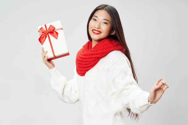 Boldog nő piros sálban mosolyog a kamerába és egy ajándék. — Stock Fotó