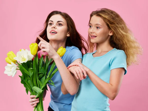 Uma mulher olha com interesse para o lado um buquê de flores e menina — Fotografia de Stock