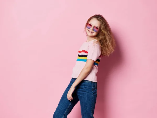Счастливая девушка в очках и в полосатой футболке на розовом фоне смеется — стоковое фото