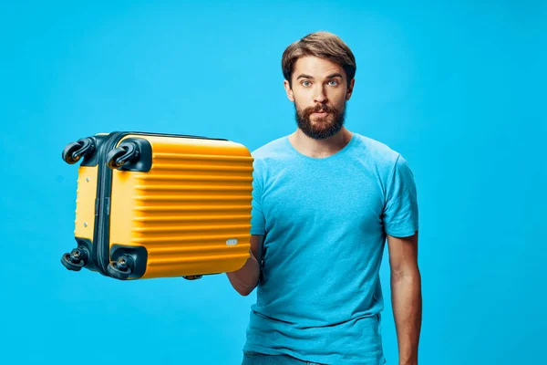 A guy with a suitcase in his hand looks at the camera — Stock Photo, Image