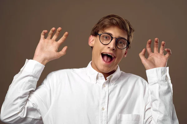 Emotionaler Kerl mit Brille überrascht mit seinen Händen — Stockfoto