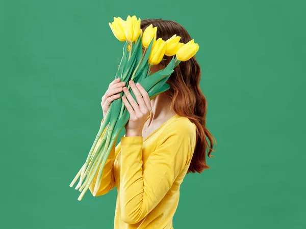Красива жінка тримає букет жовтих квітів перед обличчям — стокове фото