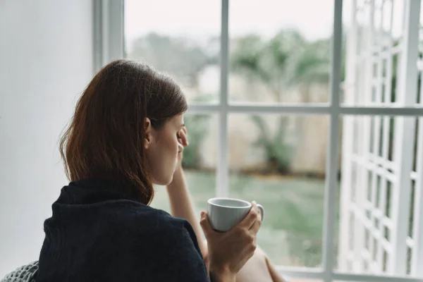 Расстроенная женщина с чашкой кофе по утрам — стоковое фото