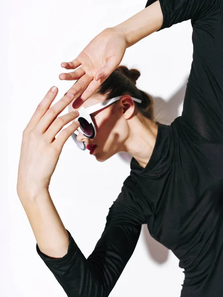 Mujer en ropa oscura y gafas de sol se esconde del sol — Foto de Stock