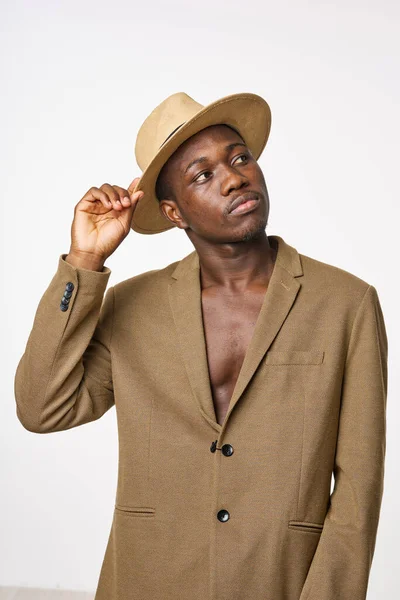 Un caballero de aspecto africano con sombrero y chaqueta mira hacia otro lado — Foto de Stock