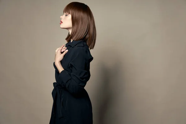 Vista lateral de uma mulher bonita em uma maquiagem casaco preto — Fotografia de Stock