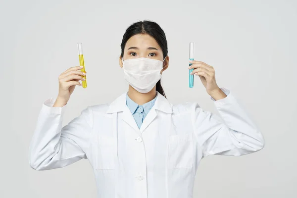 아름다운 여의사가 의료 코트를 입고 얼굴에 마스크를 쓴 모습 — 스톡 사진