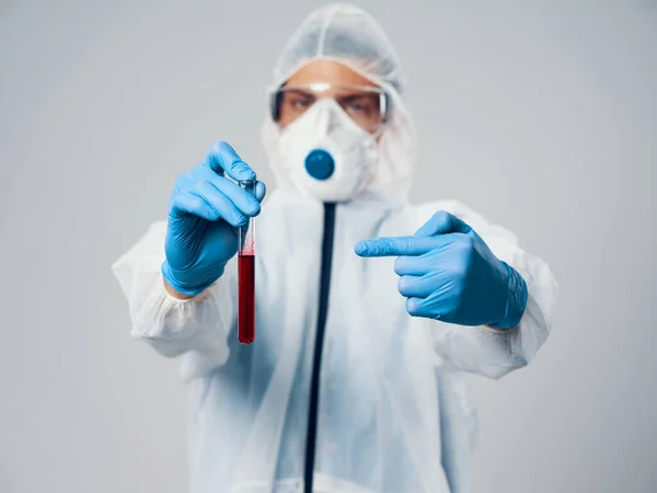 Doctor with fluid in the flask and in medical gloves mask on the face covid-19 — Stock Photo, Image