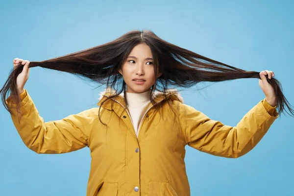 Mujer toca el cabello con las manos y una chaqueta caliente Emoción — Foto de Stock