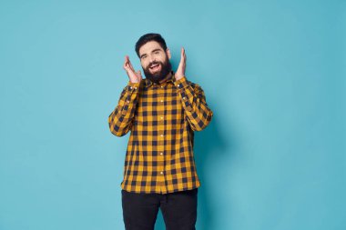 Ekose gömlekli gür sakallı bir adam gülüyor. 