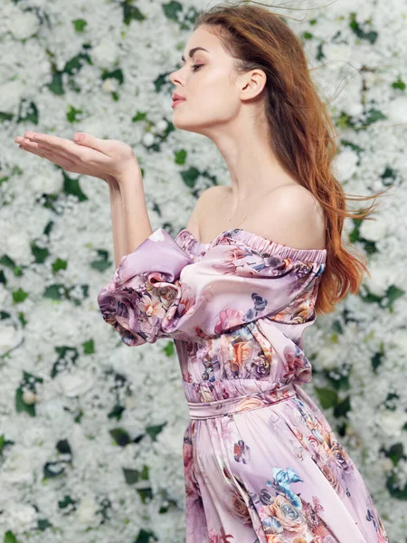 Charming lady in a pink dress on a floral background