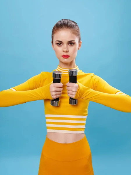 Mulher desportiva com halteres nas mãos de um suéter figura fina — Fotografia de Stock