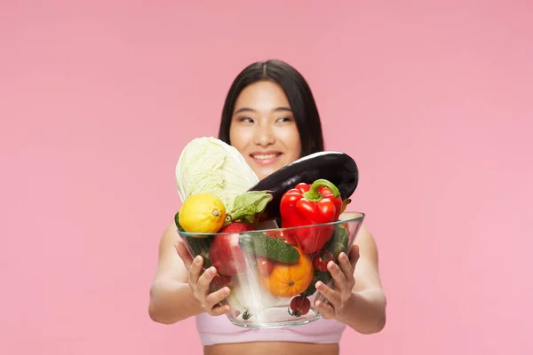 Una mujer con comida fresca en un plato sonríe —  Fotos de Stock