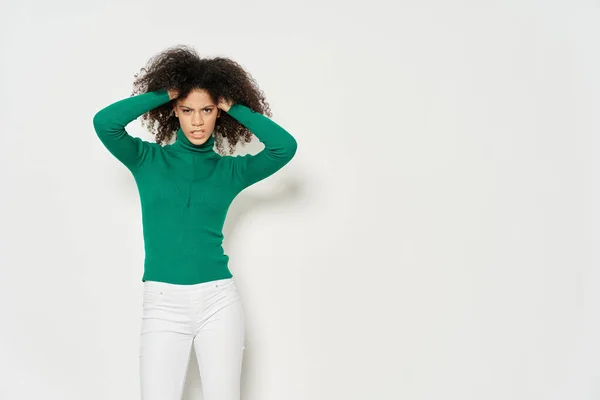 Modelo feminino atraente em uma camisola verde toca sua cabeça — Fotografia de Stock