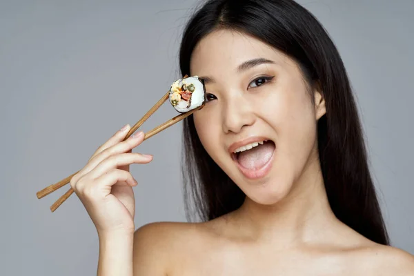 Mujer feliz con sushi en un palo de madera Japón —  Fotos de Stock