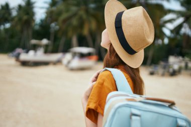 Adada sırt çantası ve şapkası olan sevimli bir gezgin.