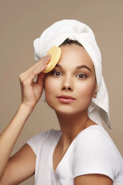 Hezká dívka s měkkou houbou v ruce a ručníkem na hlavě — Stock fotografie
