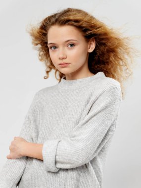 Saçları ve kalın süveteri olan güzel bir kız. 