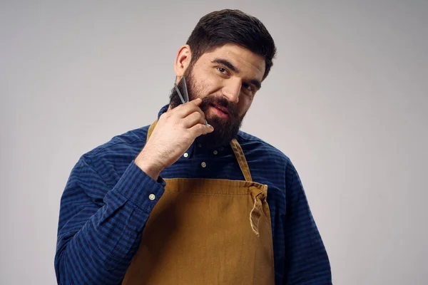 Cabeleireiro bonito com barbearia barba e avental camisa — Fotografia de Stock